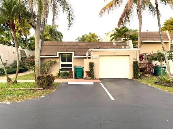 a view of a house with backyard and trees