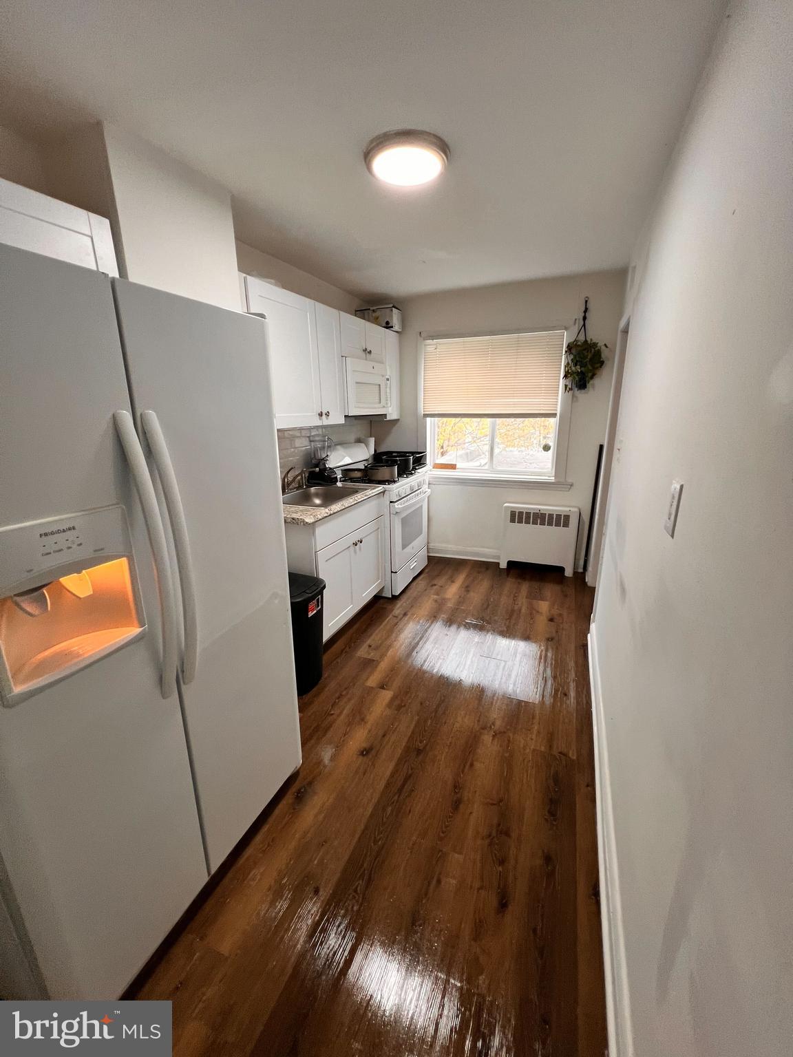8529 Chestnut Oak Road Parkville, MD 21234 - Photo 13 of 23 a kitchen with stainless steel appliances a refrigerator a sink a stove a washer dryer and white cabinets