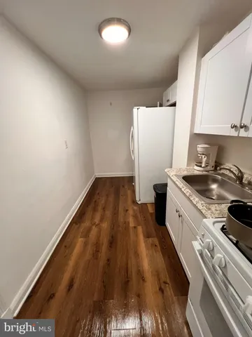 a kitchen with a sink and wooden floor