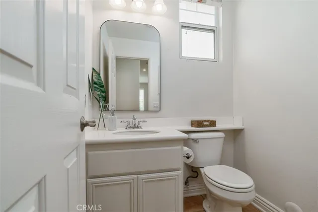 a bathroom with a toilet a sink and mirror