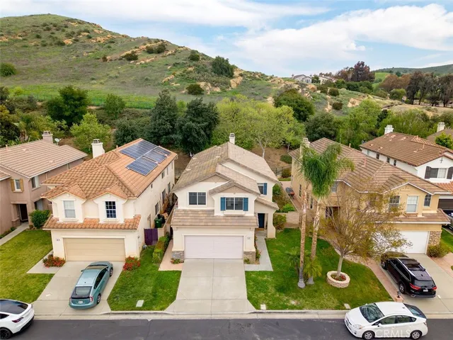 an aerial view of residential houses with outdoor space and parking