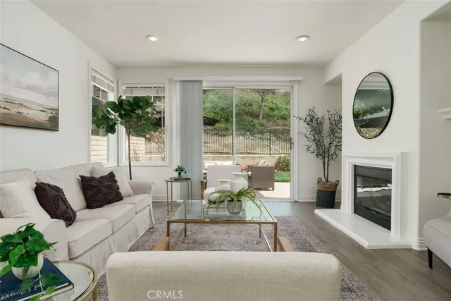 a living room with furniture a fireplace and a large window