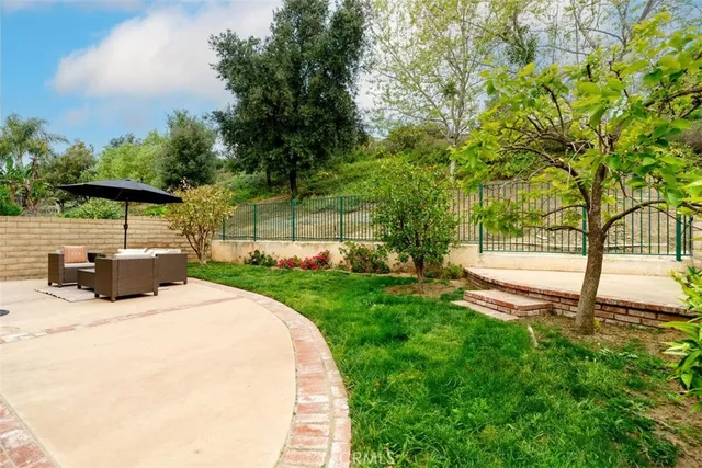 a view of a house with backyard and sitting area