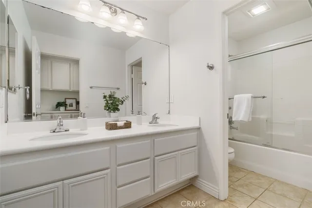 a bathroom with a double vanity sink a mirror and a bathtub