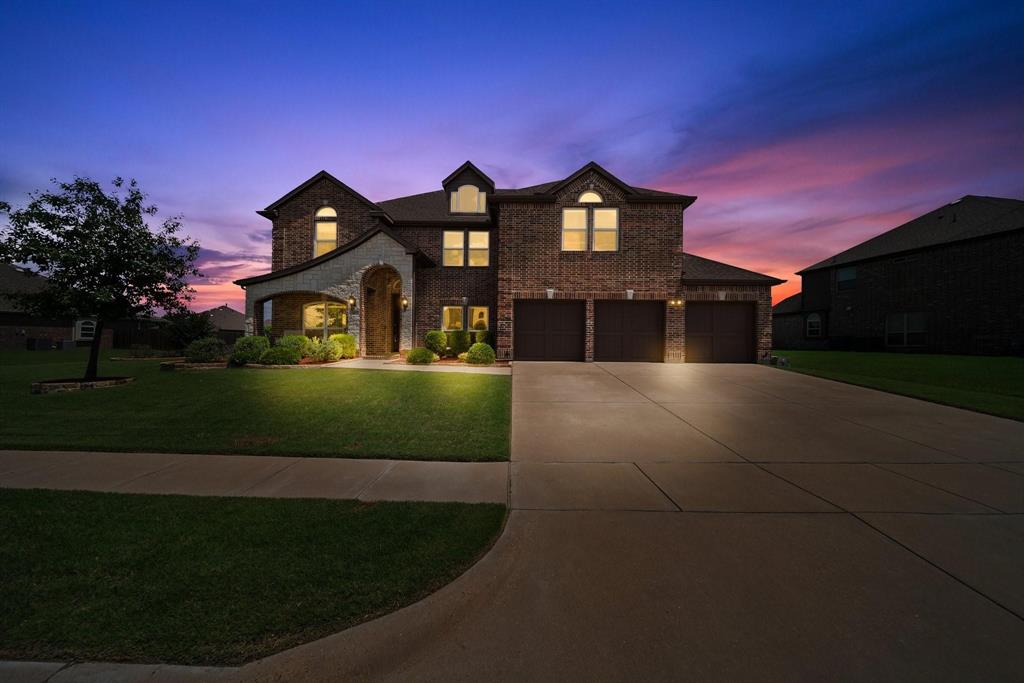 a front view of a house with a garden and yard