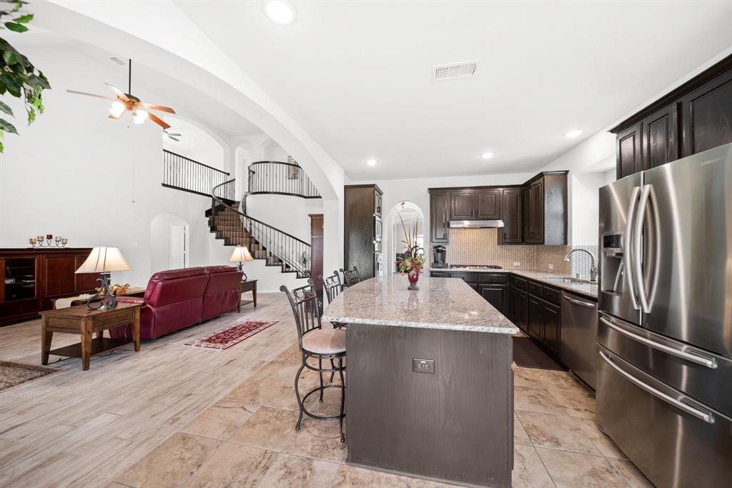 412 Bastrop Road Forney, TX 75126 - Photo 11 of 39 a kitchen with stainless steel appliances kitchen island granite countertop a refrigerator a stove and a sink with wooden floor
