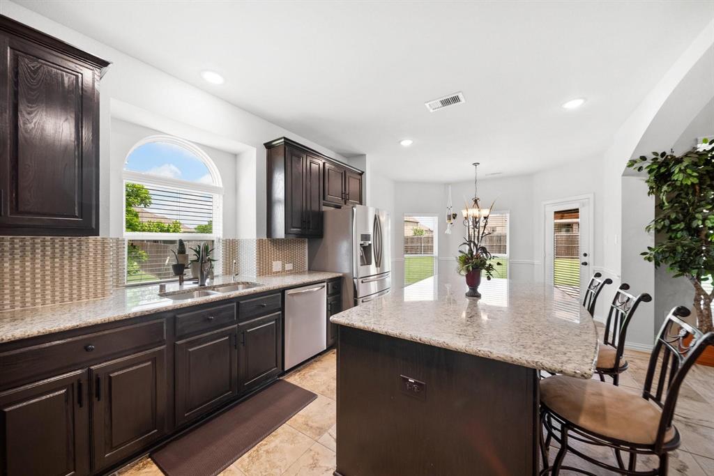 412 Bastrop Road Forney, TX 75126 - Photo 12 of 39 a kitchen with stainless steel appliances granite countertop a sink table and chairs