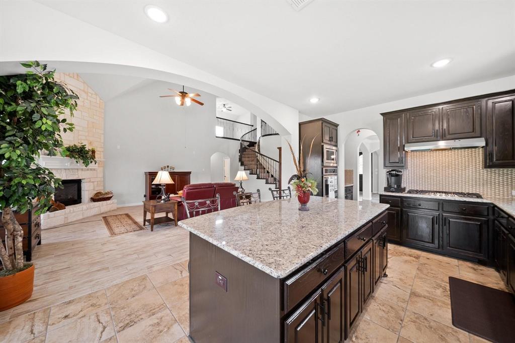 412 Bastrop Road Forney, TX 75126 - Photo 13 of 39 a kitchen with granite countertop a table chairs stove and refrigerator