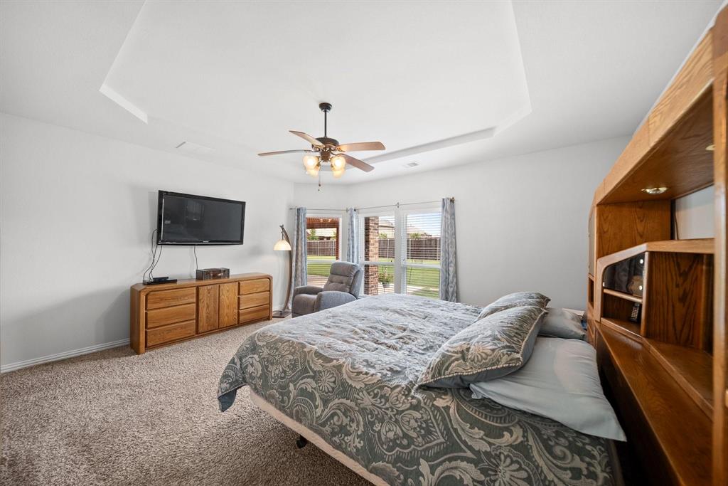 412 Bastrop Road Forney, TX 75126 - Photo 24 of 39 a bedroom with a bed and a flat screen tv