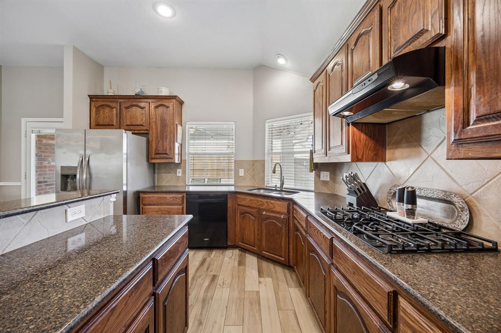 4133 Drexmore Road Fort Worth, TX 76244 - Photo 11 of 31 a kitchen with stainless steel appliances granite countertop a sink stove and refrigerator