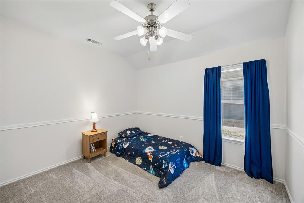 4133 Drexmore Road Fort Worth, TX 76244 - Photo 22 of 31 a bedroom with a bed and a chandelier