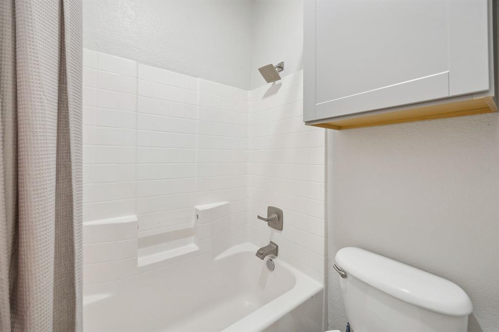 4133 Drexmore Road Fort Worth, TX 76244 - Photo 24 of 31 a white toilet sitting next to a bath tub
