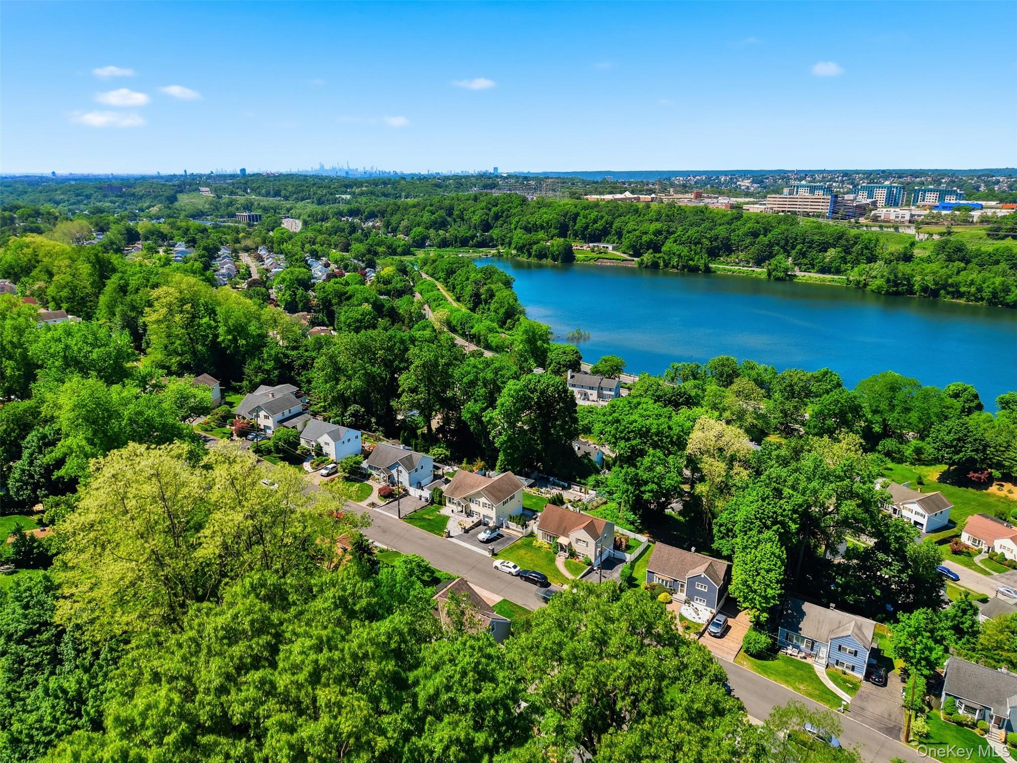 29 Montrose Road Yonkers, NY 10710 - Photo 34 of 39 Aerial perspective showcasing a residential area with mature tree coverage, a prominent body of water, and distant city architecture