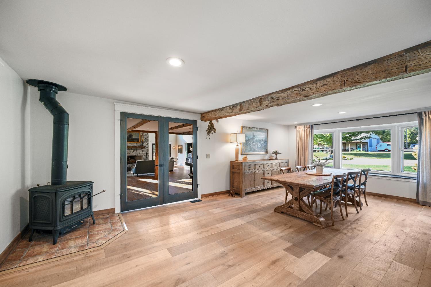 9463 Stoops Road Dillsboro, IN 47018 - Photo 15 of 99 Step through the glass doors from the Great Room into the heart of the old homestead... now a spacious & open DIning Room, kitchen & Living Room Combination. An updated woodstove sits in the corner, ready to warm the space on a chilly winter evening. A large bay window opens the Dining Room to a view of the front lawns & driveway.