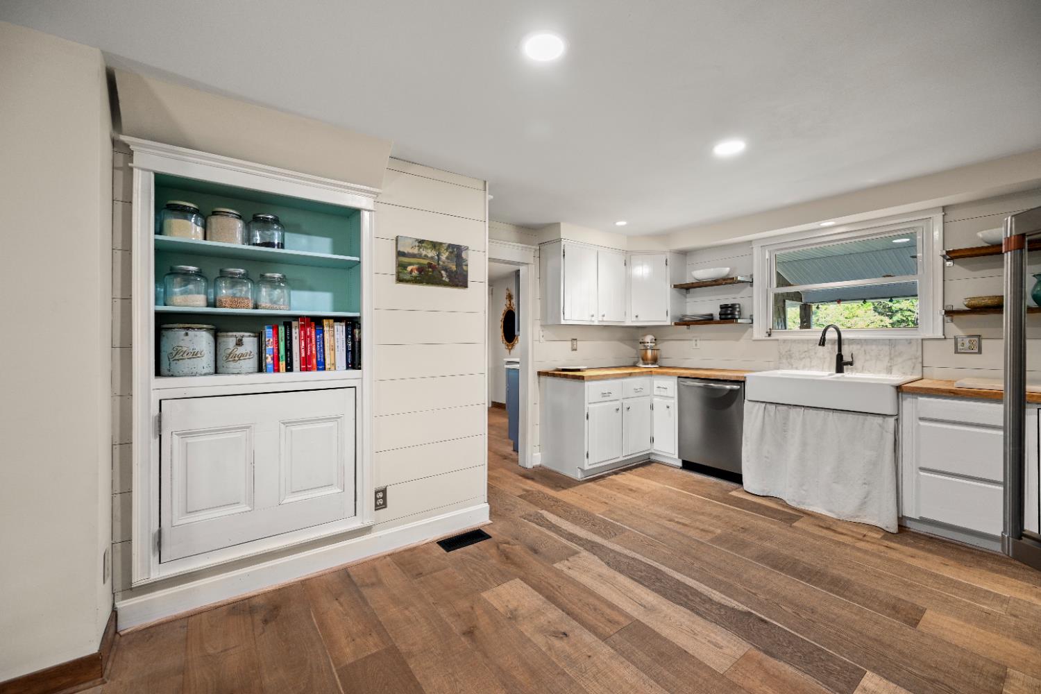 9463 Stoops Road Dillsboro, IN 47018 - Photo 22 of 99 A charming built-in cabinet in the side wall provides character and convenient storage. More plank flooring here creates a continuous flow between the different spaces.