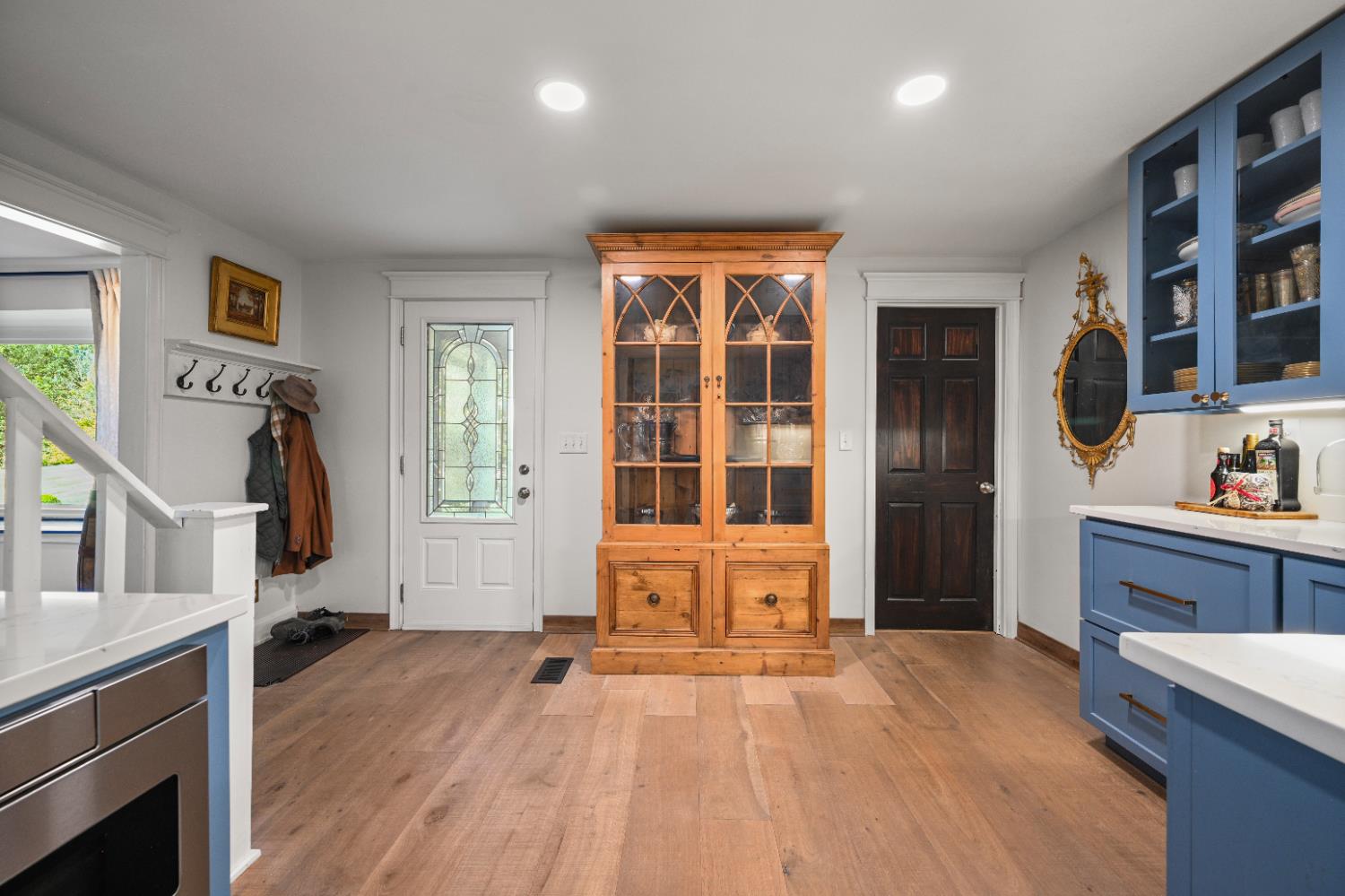 9463 Stoops Road Dillsboro, IN 47018 - Photo 24 of 99 The entry door to the left, the original door to the home, now leads into a screened in porch. Glass door upper cabinets in the Butler's Pantry provide a dressy touch, and the door to the right leads into a spacious main level bedroom suite - one of the earlier additions to the original home.