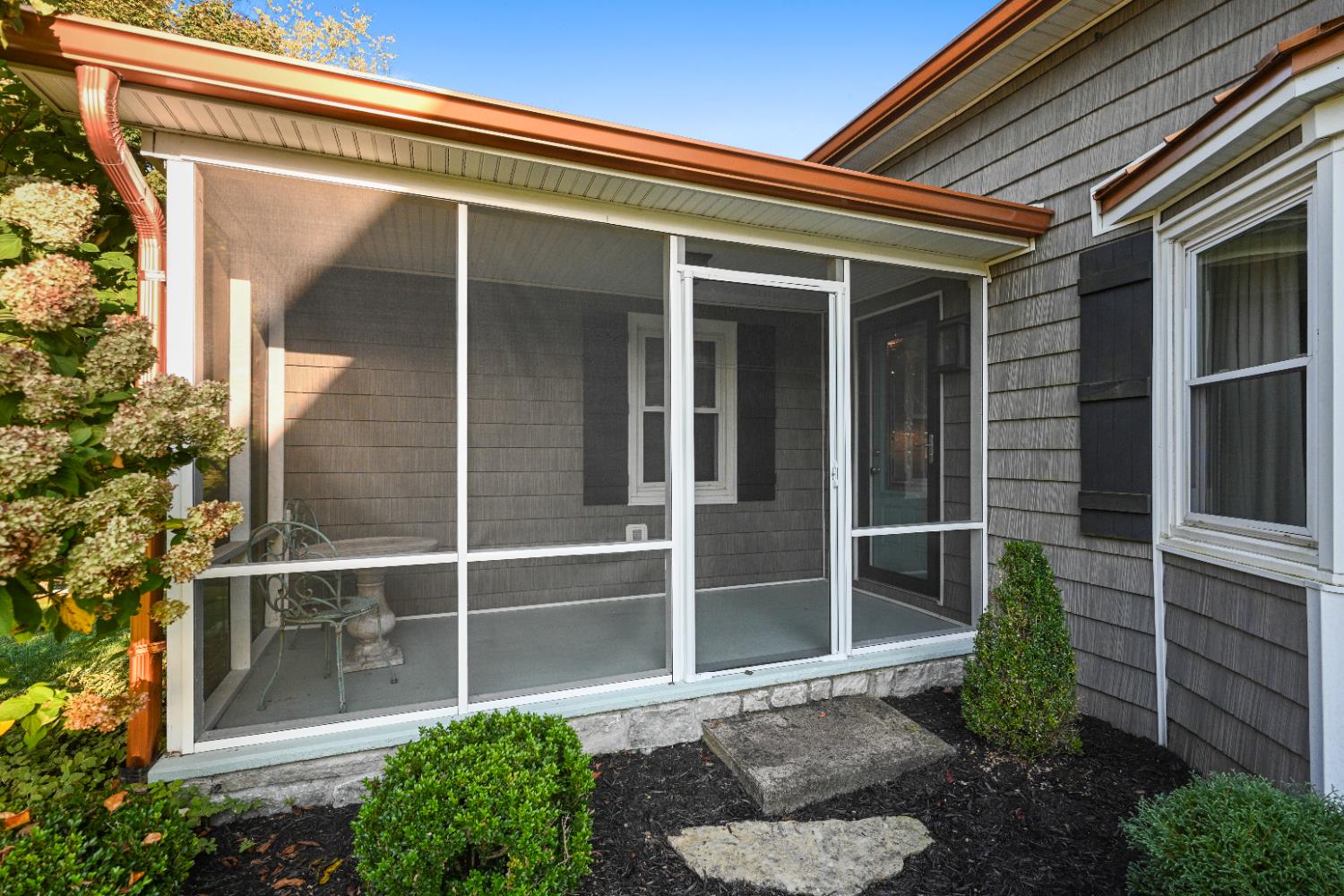 9463 Stoops Road Dillsboro, IN 47018 - Photo 27 of 99 The screened porch can be accessed from the front of the house by a stone pathway winding through landscaping beds.