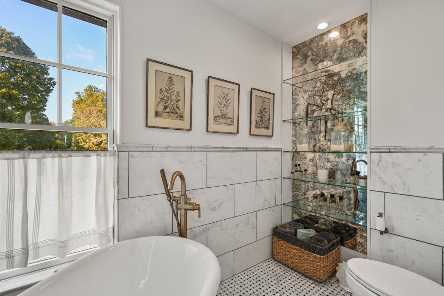 9463 Stoops Road Dillsboro, IN 47018 - Photo 43 of 99 Decorative mirror tile on an accent wall near the tub & toilet has handy glass shelving for towels or accent pieces! A large window lets in plenty of natural light, as well as fresh air for ventilation when needed.