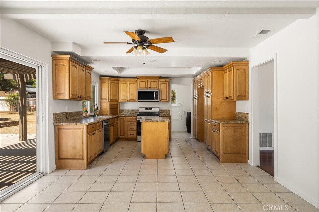 16481 Valle Vista Way Riverside, CA 92506 - Photo 13 of 73 a kitchen with a refrigerator a sink and a stove top oven