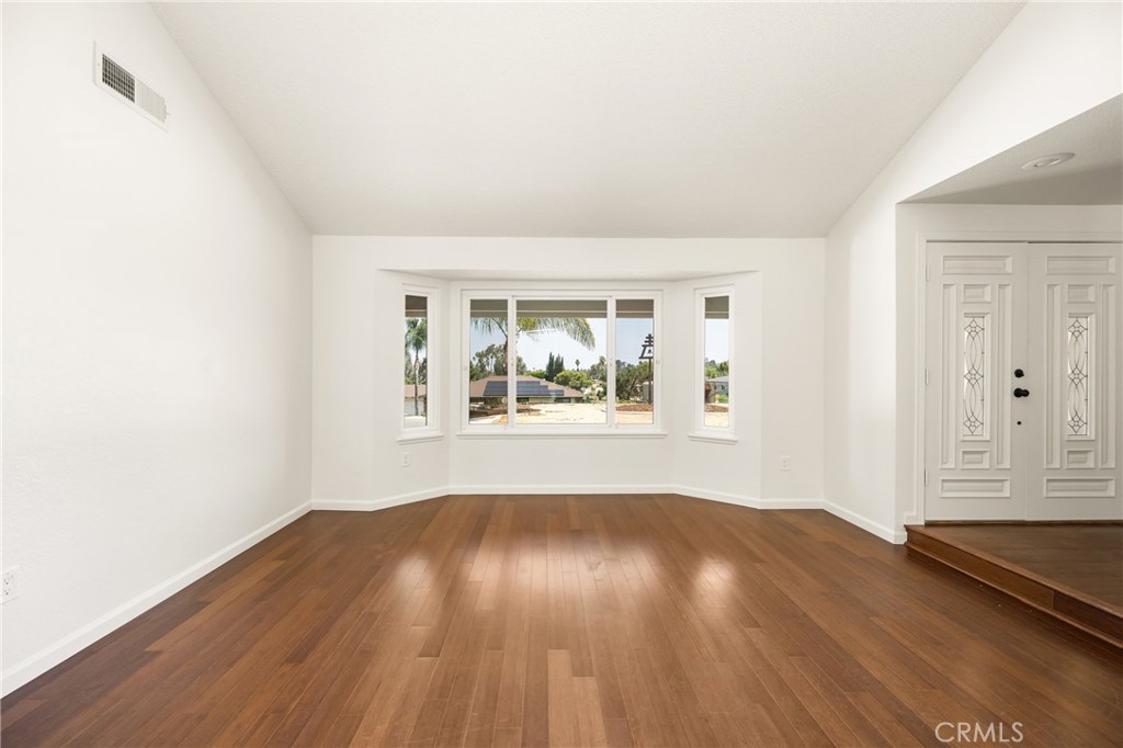 16481 Valle Vista Way Riverside, CA 92506 - Photo 19 of 73 an empty room with wooden floor and windows