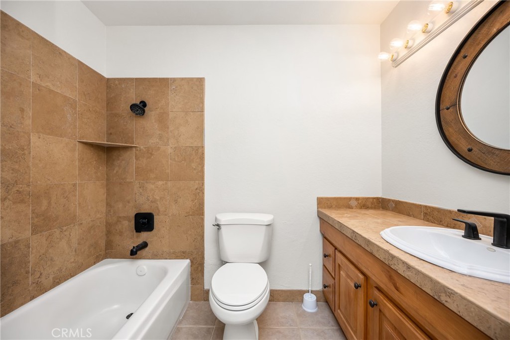 16481 Valle Vista Way Riverside, CA 92506 - Photo 28 of 73 a bathroom with a granite countertop toilet sink and mirror