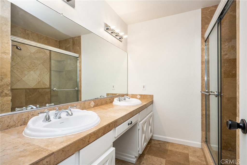 16481 Valle Vista Way Riverside, CA 92506 - Photo 33 of 73 a bathroom with a granite countertop sink and a mirror