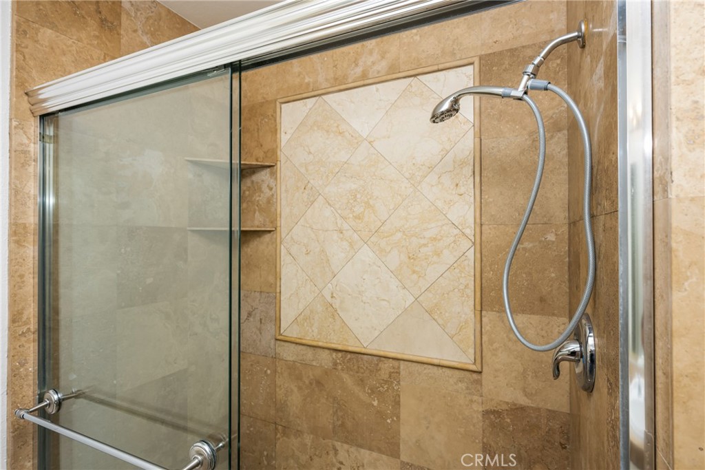 16481 Valle Vista Way Riverside, CA 92506 - Photo 35 of 73 a bathroom with a glass shower door and mirror