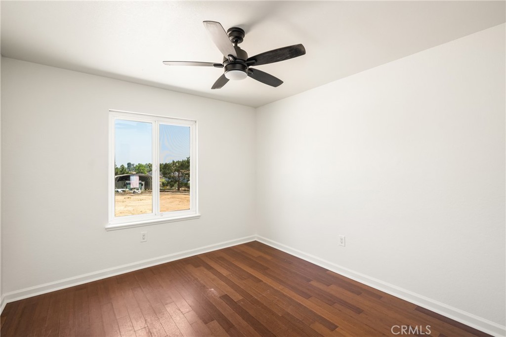16481 Valle Vista Way Riverside, CA 92506 - Photo 37 of 73 an empty room with wooden floor fan and windows