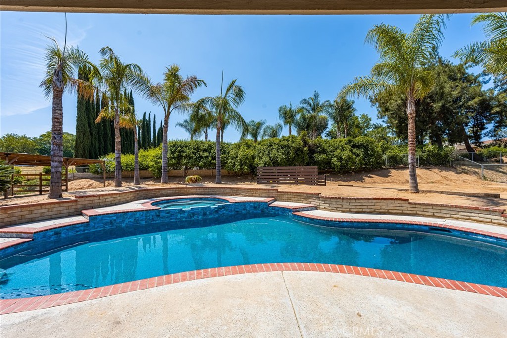 16481 Valle Vista Way Riverside, CA 92506 - Photo 47 of 73 a view of swimming pool with a lawn chairs under palm trees