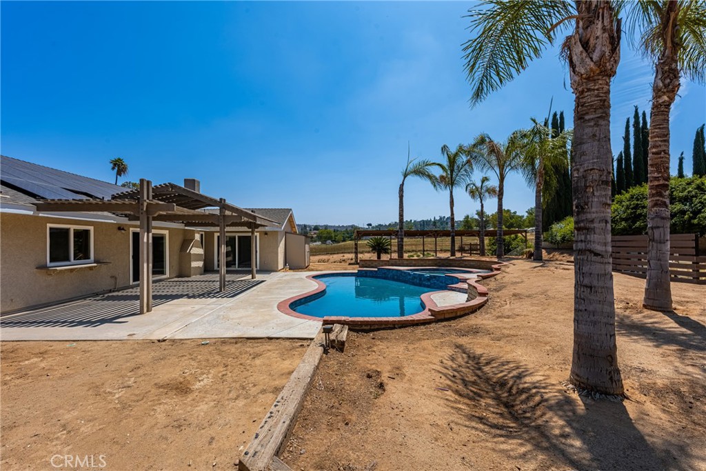 16481 Valle Vista Way Riverside, CA 92506 - Photo 49 of 73 a view of a swimming pool with a chair and palm trees