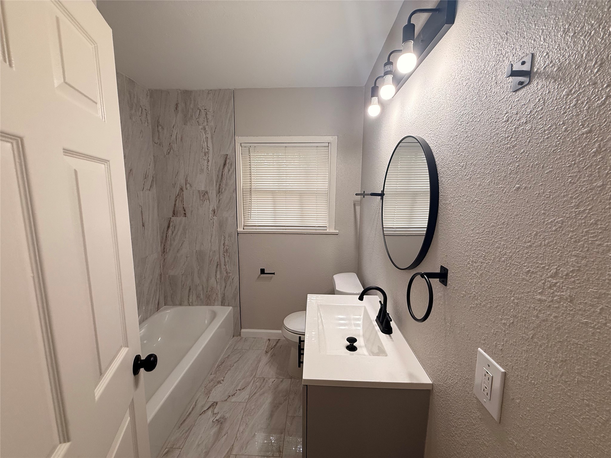 6633 Burkett Street Houston, TX 77021 - Photo 12 of 13 a bathroom with a sink a mirror a bathtub and shower