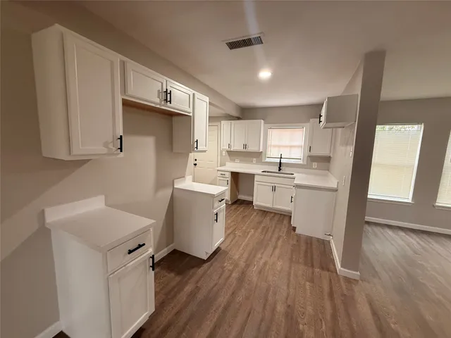 a kitchen with a sink a microwave a refrigerator and cabinets