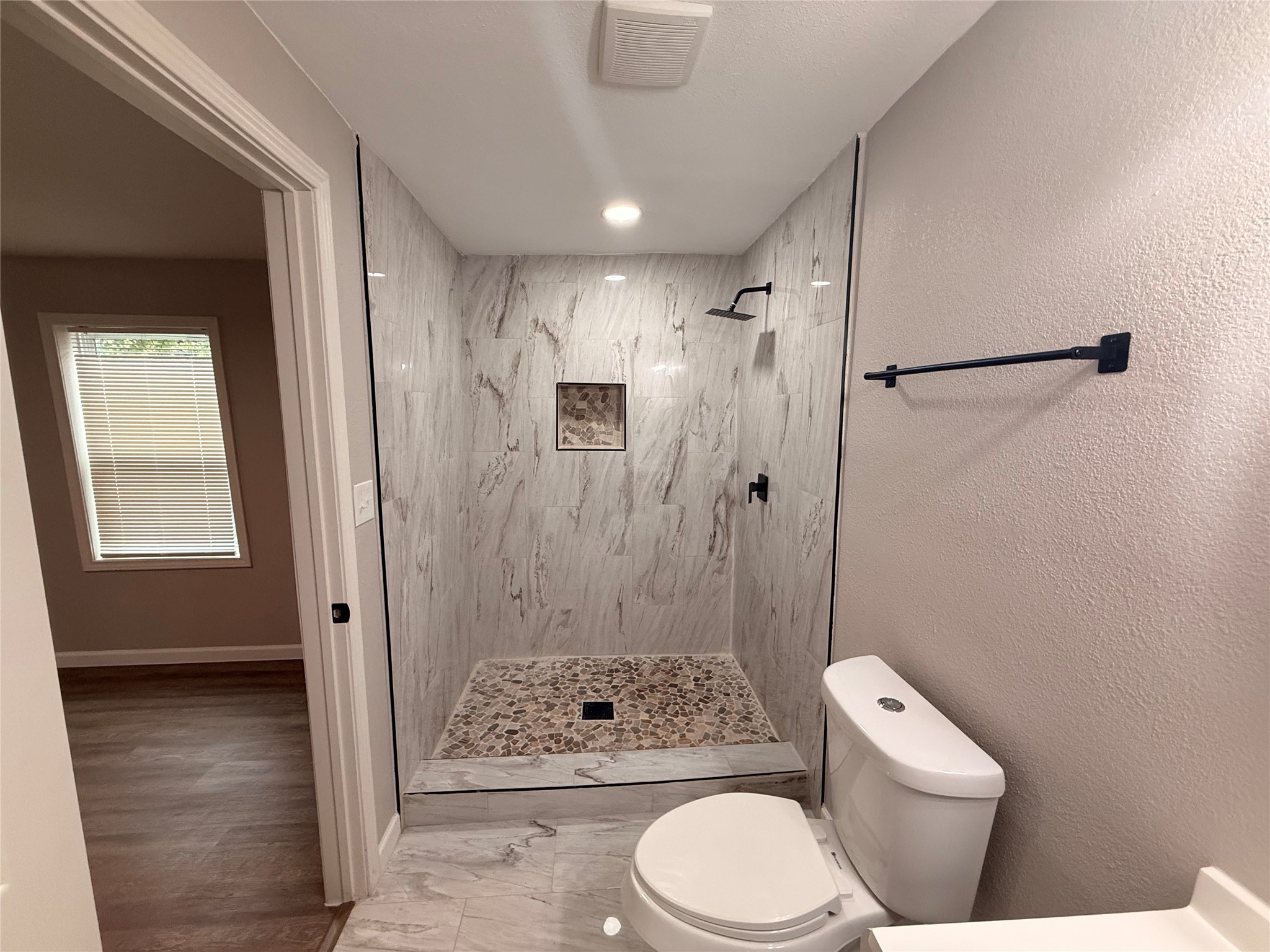 6633 Burkett Street Houston, TX 77021 - Photo 8 of 13 a bathroom with a toilet a sink a shower and a window