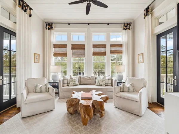 a living room with furniture and floor to ceiling windows
