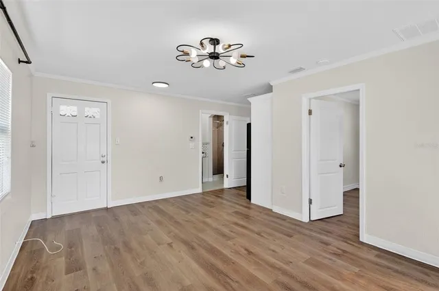 a view of an empty room with wooden floor