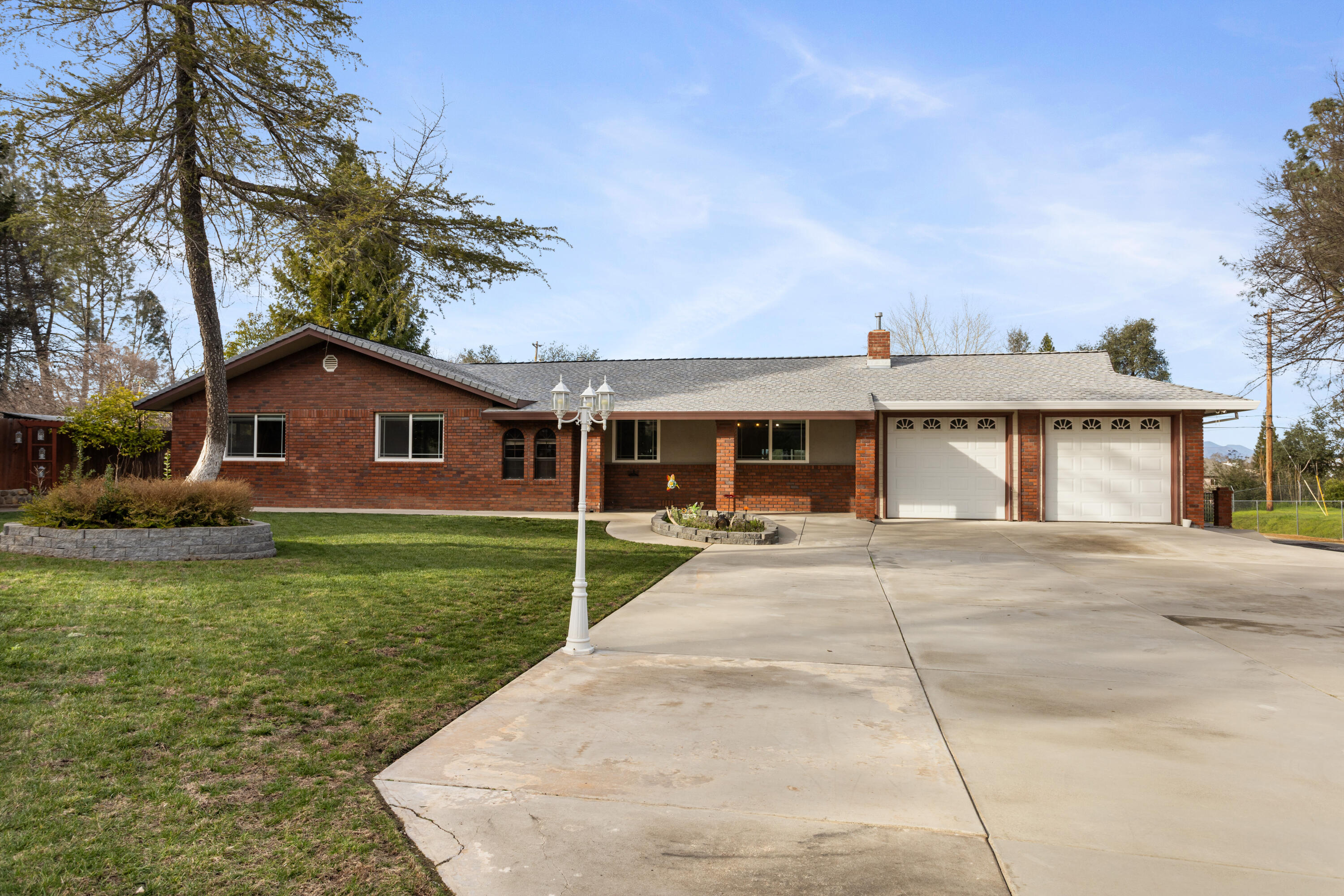 8641 Redbank Road Redding, CA 96001 - Photo 55 of 59 a front view of a house with a garden and yard