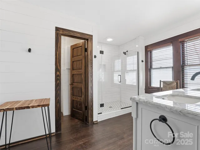a view of front door with hallway and wooden floor