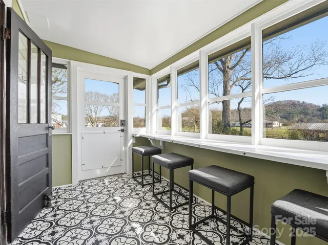a living room with a large window and furniture