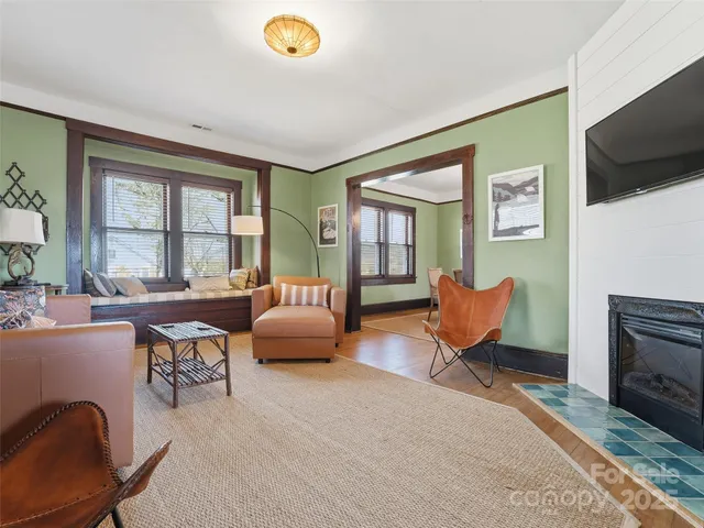 a living room with furniture a flat screen tv and a fireplace