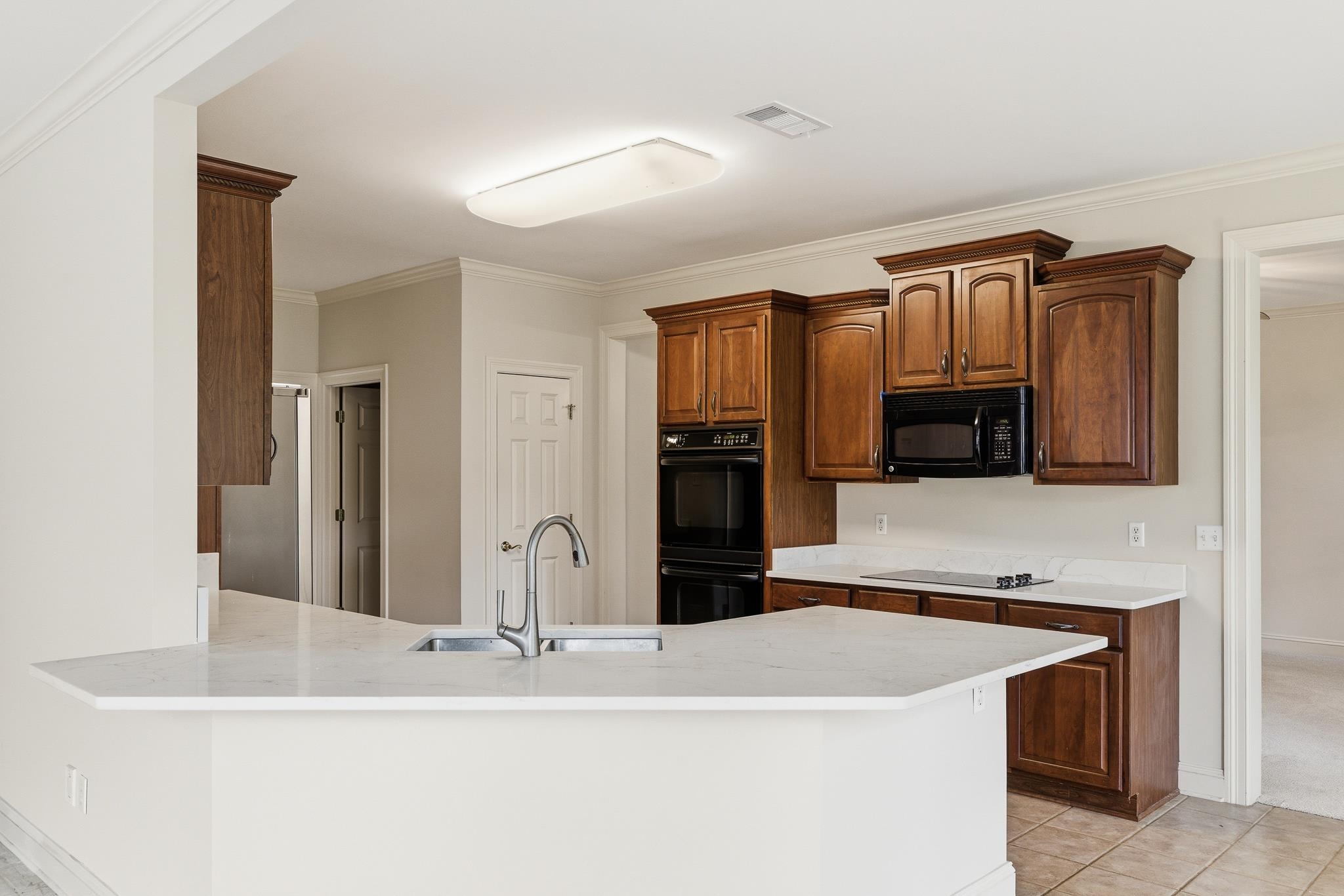 1348 Colbert Cove Collierville, TN 38017 - Photo 12 of 34 a kitchen with stainless steel appliances kitchen island granite countertop a refrigerator and a stove top oven