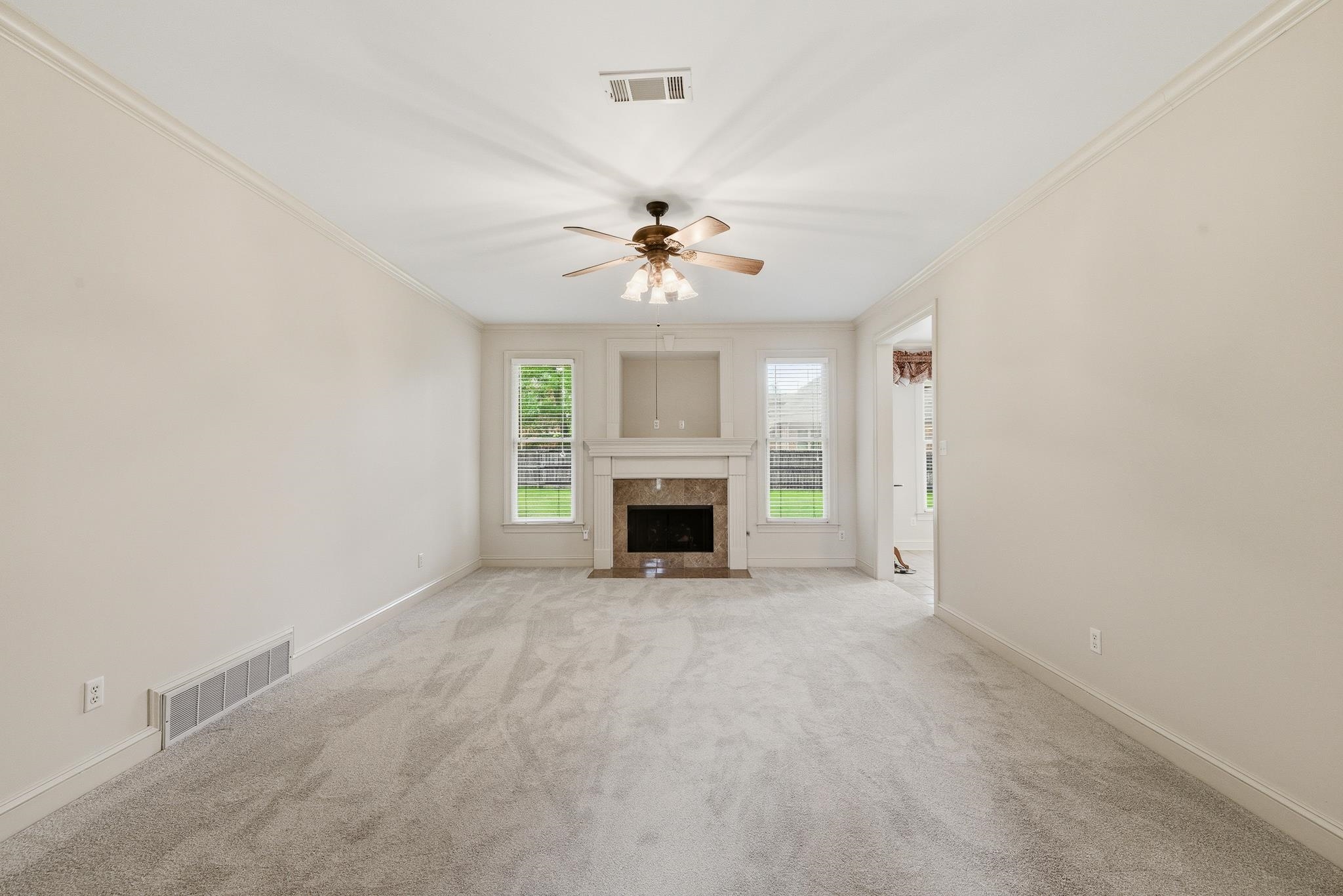 1348 Colbert Cove Collierville, TN 38017 - Photo 7 of 34 an empty room with a fireplace and a ceiling fan