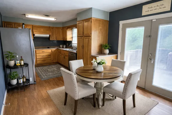 a kitchen with a table chairs refrigerator and microwave