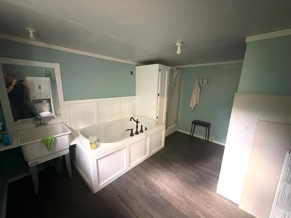 a bathroom with a tub sink and mirror
