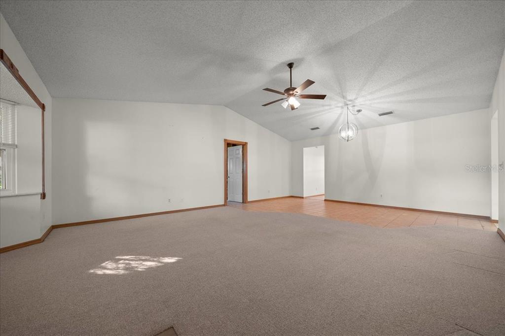 8431 Southwest 93rd Place, Unit A Ocala, FL 34481 - Photo 13 of 56 en empty room with windows and ceiling fan