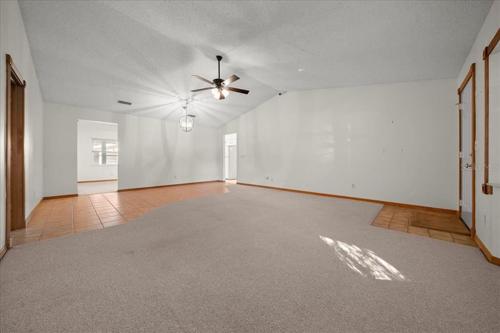 8431 Southwest 93rd Place, Unit A Ocala, FL 34481 - Photo 14 of 56 an empty room with chandelier fan and windows