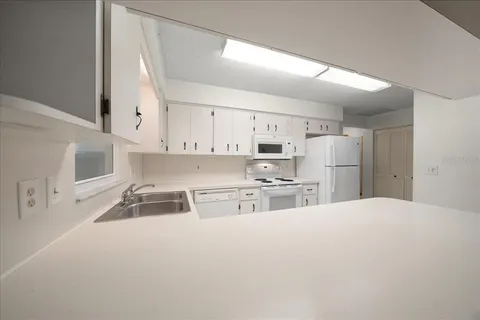 a kitchen with granite countertop a sink a stove and cabinets