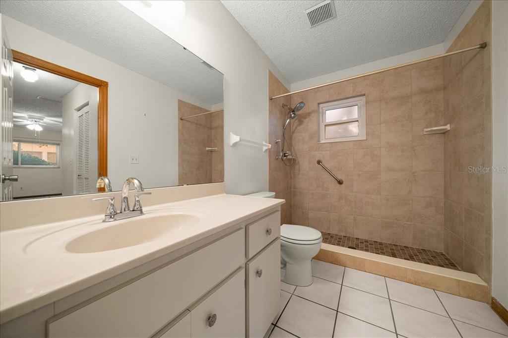 8431 Southwest 93rd Place, Unit A Ocala, FL 34481 - Photo 35 of 56 a bathroom with a sink a toilet a mirror and shower