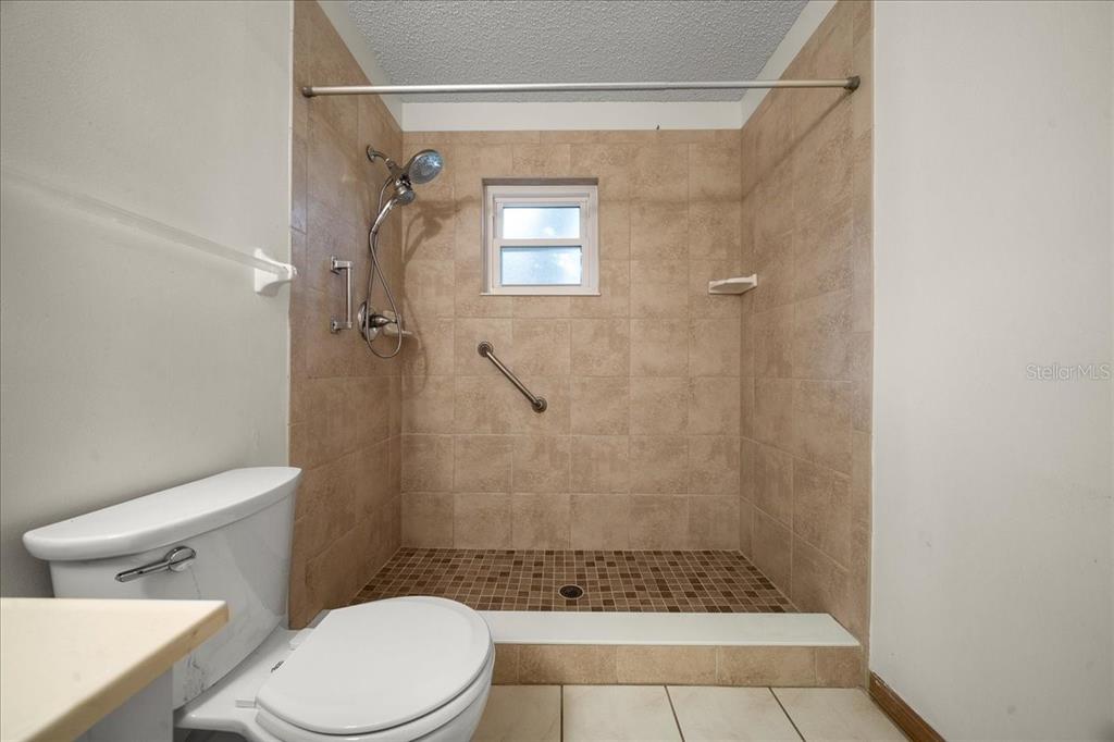 8431 Southwest 93rd Place, Unit A Ocala, FL 34481 - Photo 36 of 56 a bathroom with a toilet and shower