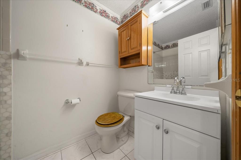 8431 Southwest 93rd Place, Unit A Ocala, FL 34481 - Photo 39 of 56 a bathroom with a sink toilet and mirror