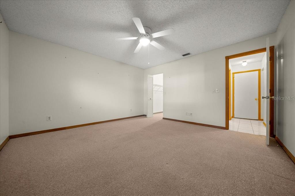 8431 Southwest 93rd Place, Unit A Ocala, FL 34481 - Photo 42 of 56 an empty room with a ceiling fan and a window